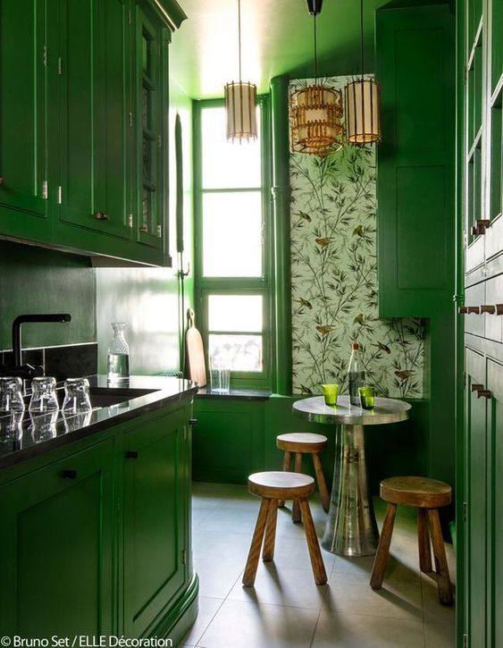 a bright yellow kitchen with floral wallpaper, a metal table, wooden stools and pendant lamps is a very sophisticated space