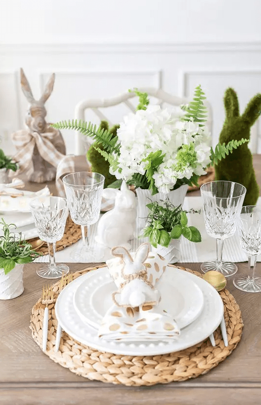 a charming Easter tablescape with a striped runner and polka dot napkins, woven placemats, greenery and white blooms plus binnes