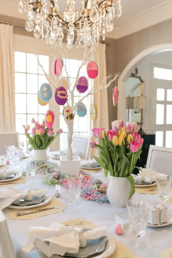 a colorful Easter tablescape with bold tulips, a funny Easter tree as a centerpiece, colorful yarn and pastel placemats