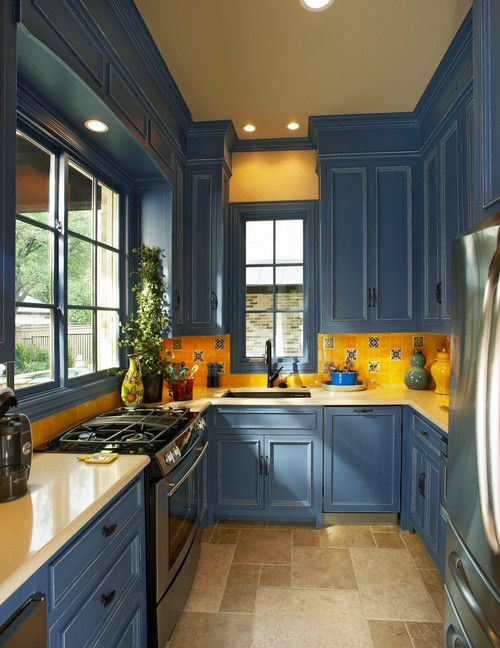a colorful kitchen with navy cabinets and a bold yellow backsplash, with a bright yellow countertops feels country-like and fun
