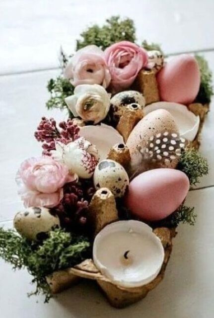 a creative Easter centerpiece of pink and speckled eggs and egg shell candles and moss and blooms is wow