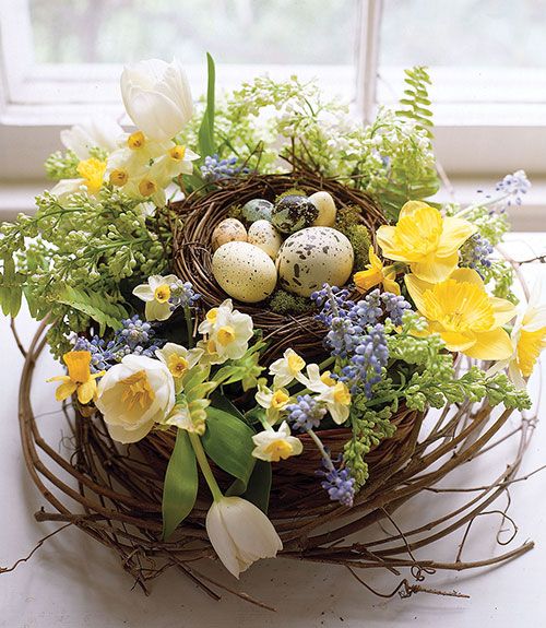 a dreamy Easter centerpiece of a nest with yellow and white tulips, hyacinths and speckled faux eggs