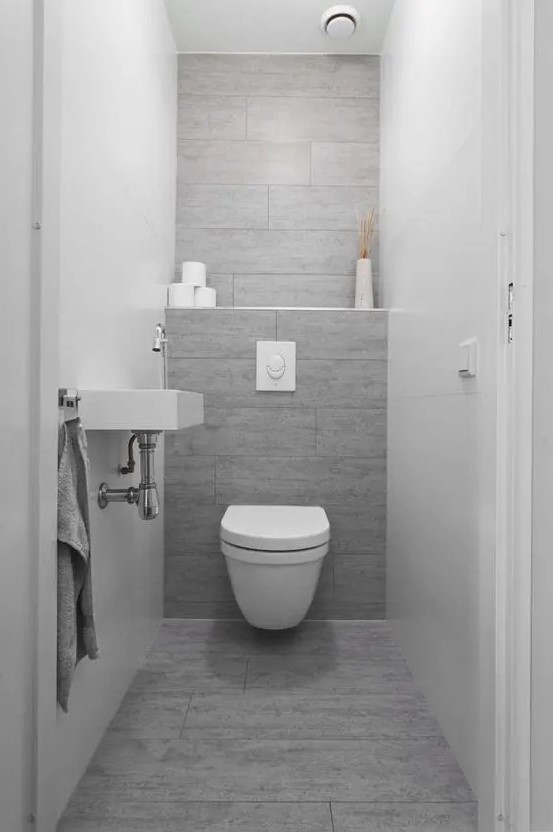 a grey wood-looking tile wall and floor make an accent in this neutral space