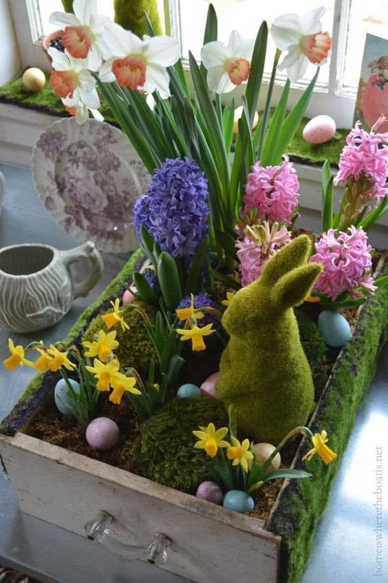 a lovely Easter decoration of a drawer with soil and moss, colorful spring bulbs, pastel eggs and a moss bunny is amazing