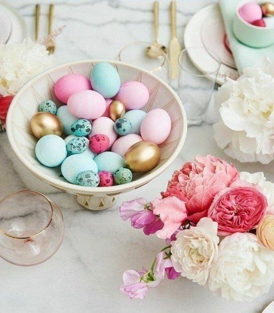 a modern Easter centerpiece of a bowl with turquoise, pink and gilded eggs is a cool solution that you can easily realize