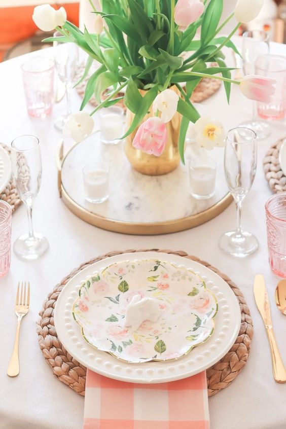 a modern rustic Easter table with fresh pink and white tulips, woven placemats, printed plates, bunnies and pink touches