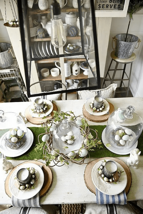 a rustic Easter table setting with wood slices, striped napkins, tin can candles, vine wreaths with eggs