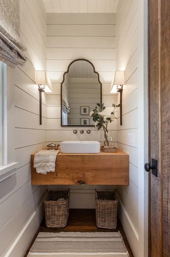 a rustic butcher's countertop makes a statement in this powder room, and baskets under it add a cozy feel