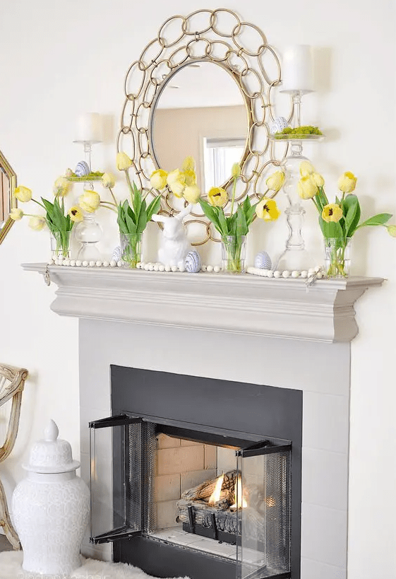 a simple Easter mantel with yellow tulips, bunnies, blue marble eggs is a cool solution and you can recreate all this easily