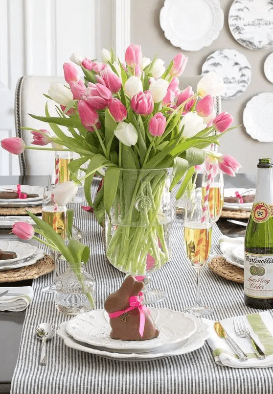 a simple Easter tablescape with a striped runner, woven placemats, vintage porcelain and chocolate bunnies for each palce setting