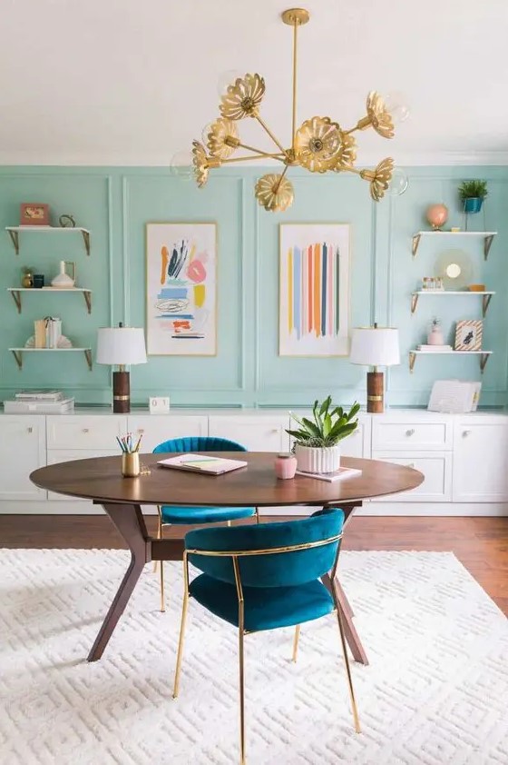 a sophisticated home office with aqua panels, open shelves, a long storage unit, an oval desk and lovely navy chairs