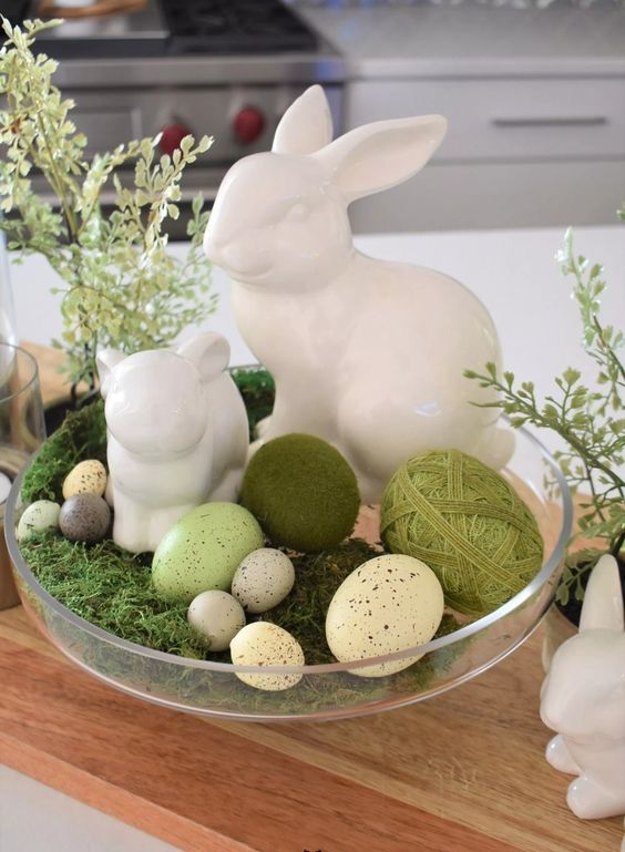 an Easter decoration of a bowl with moss, speckled eggs and bunnies is adorable, it looks super cute and lovely