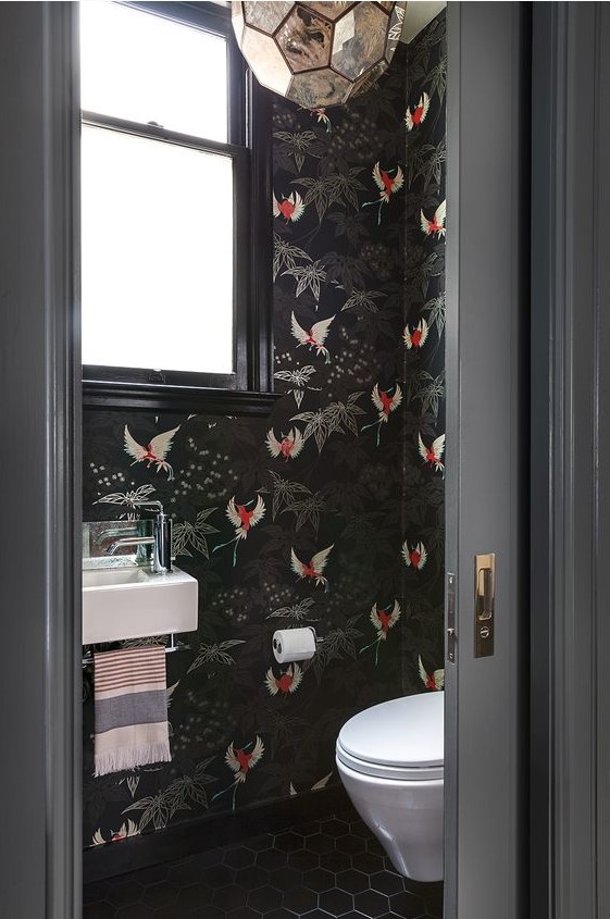 black wallpaper with bold red bird prints to make the powder room wow