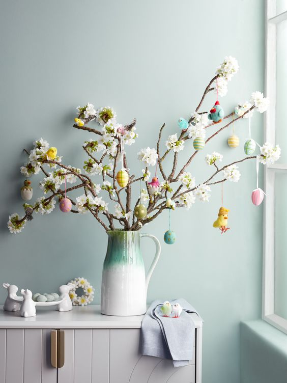 faux blooming branches decorated with pastel-colored plastic eggs and a chick are a cool Easter tree to try