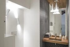 the sink zone is accentuated with grey mosaic tiles, and the toilet zone is lit up