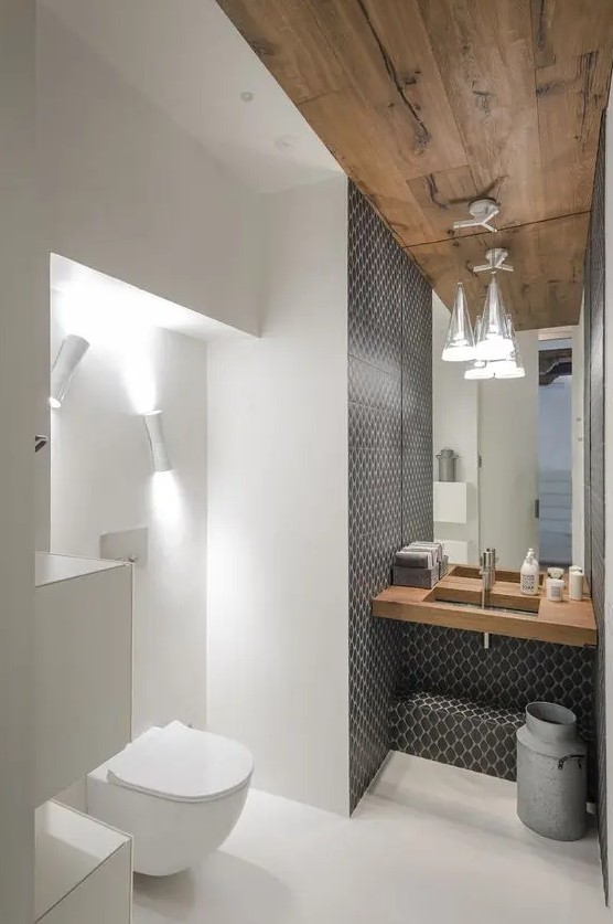 the sink zone is accentuated with grey mosaic tiles, and the toilet zone is lit up