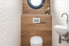 a contemporary guest toilet with wood-inspired tiles, geometric white ones, a window, a wall-mounted sink