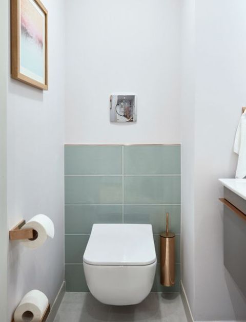 a laconic guest toilet with aqua tiles, copper touches and a floating vanity with a sink a laconic guest toilet with aqua tiles, copper touches and a floating vanity with a sink
