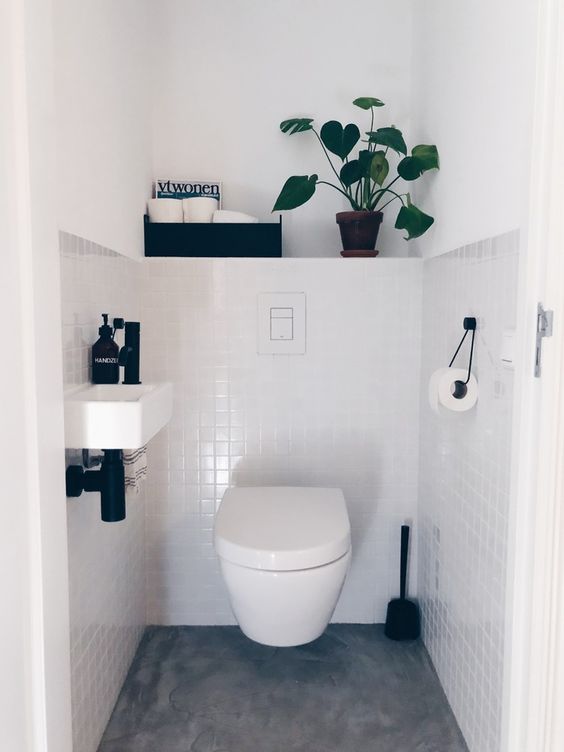 a neutral guest toilet with black touches for some drama, a wall mounted sink and a box with storage a neutral guest toilet with black touches for some drama, a wall-mounted sink and a box with storage