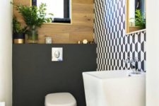 a tony guest toilet with a geometric wall, a free-standing sink, a plywood and matte black wall plus a black framed window