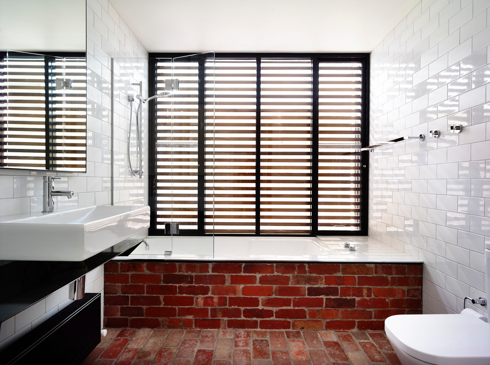 Brick floor mixed with brick bathroom cover make this bathroom's design quite interesting and unique.