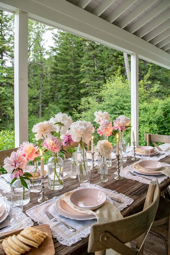 a beautiful and delicate vintage-inspired Mother's Day table setting with blush and pink blooms, white placemats, pink plates