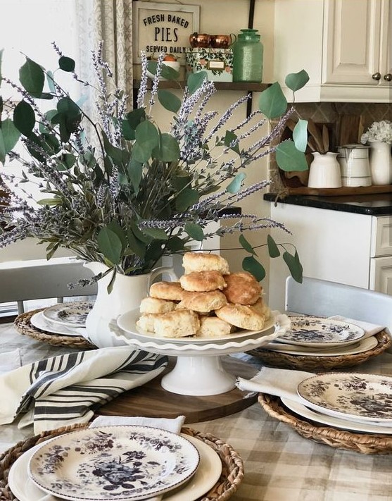 a cute rustic spring table setting with floral porcelain, striped textiles, a lavenver and eucalyptus centerpiece