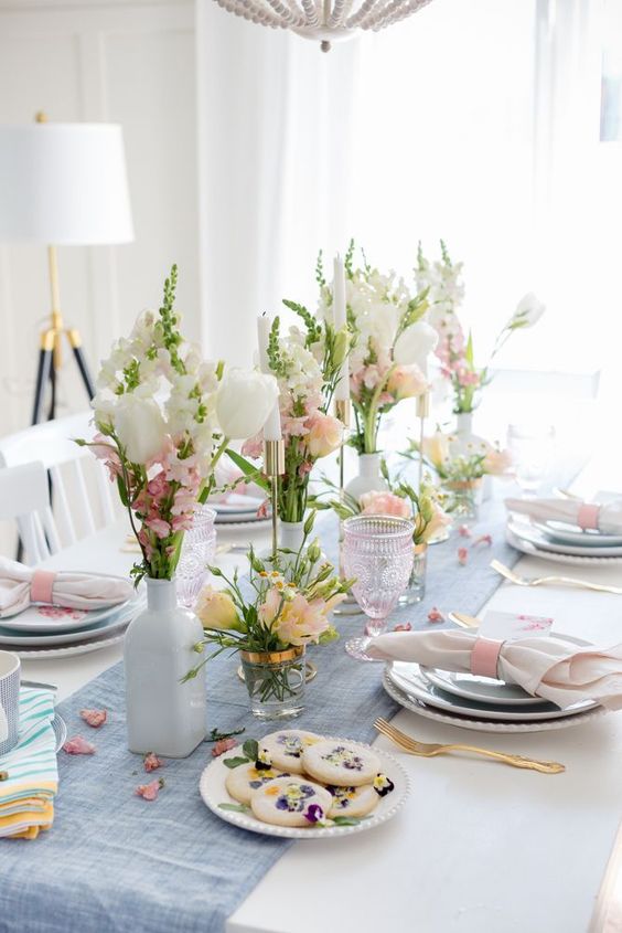 a dreamy pastel Mother's Day tablescape with pastel blooms, a blue runner and pastel napkins, pressed flower cookies
