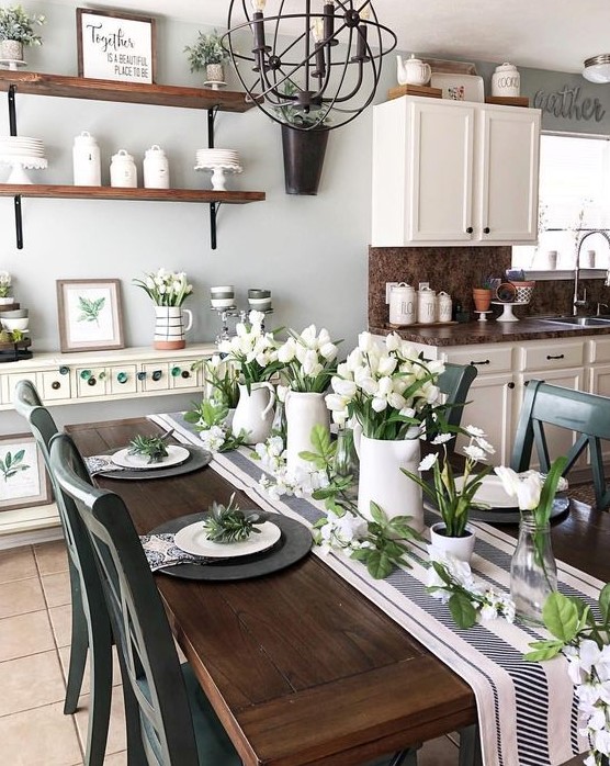 a fresh spring tablescape with a striped table runner, black matte chargers, white porcelain and white tulips centerpieces