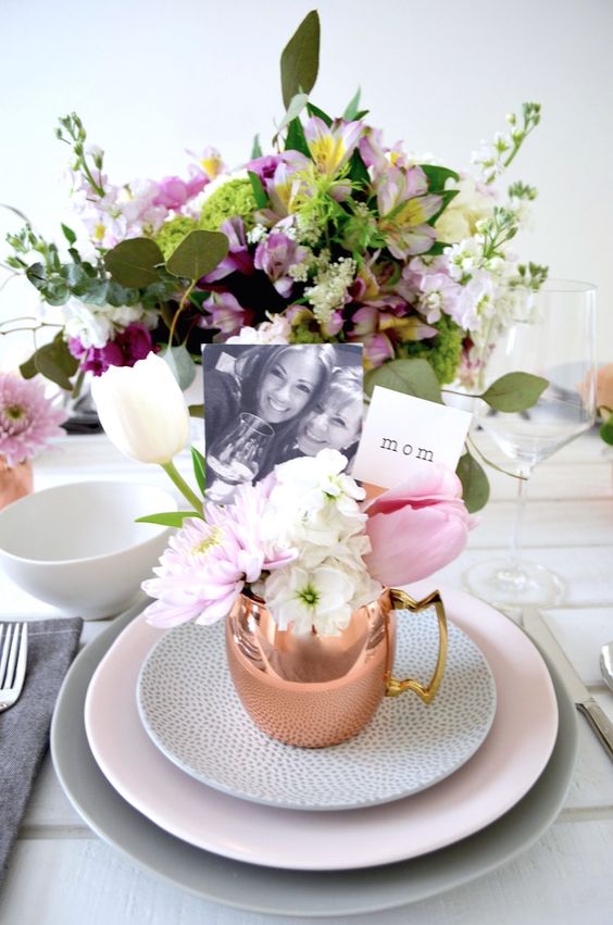 a modern Mother's Day tablescape with grey, pink and spotted plates, bold pink blooms and copper mugs