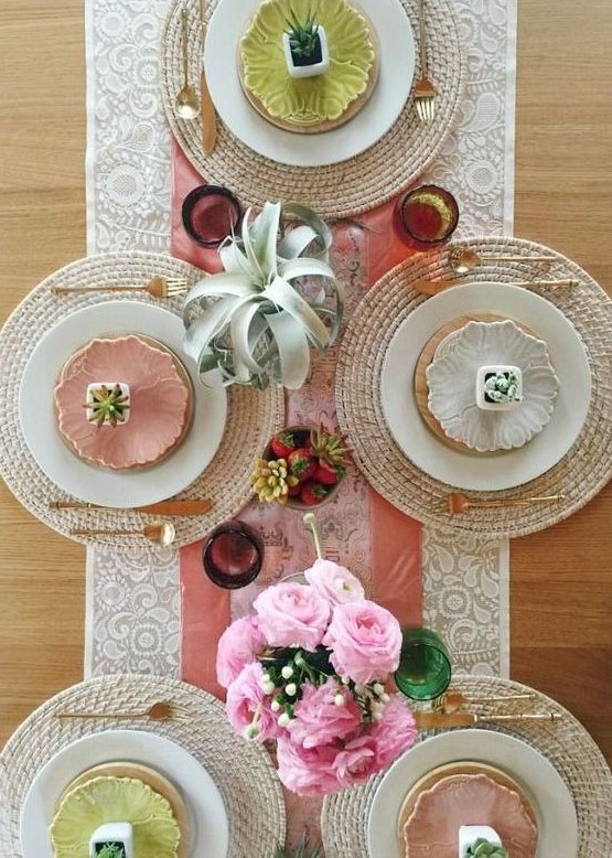a modern colorful spring tablescape with succulents, pink roses, colorful plates and wicker chargers