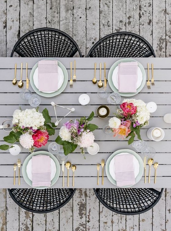 a modern spring tablescape with bright floral centerpieces, blush napkins and geometric touches