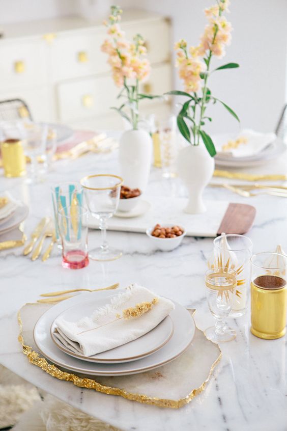 a pretty Mother's Day table setting with pastel blooms, geode placemats, gold-rimmed plates and colorful touches
