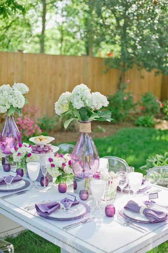 a purple Mother's Day table setting with white hydrangeas, lilac candleholders and napkins is a catchy one