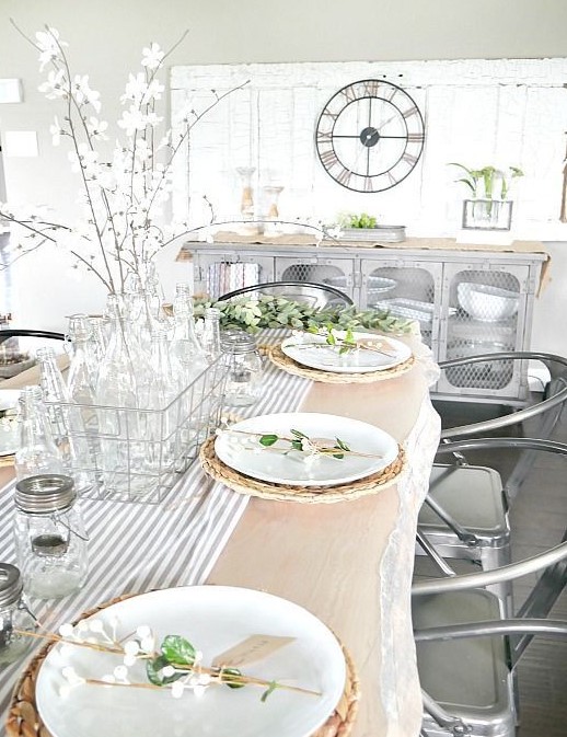 blooming branches in glass bottles and a wicker basket, blooming branch card holders, a striped runner for a neutral spring look