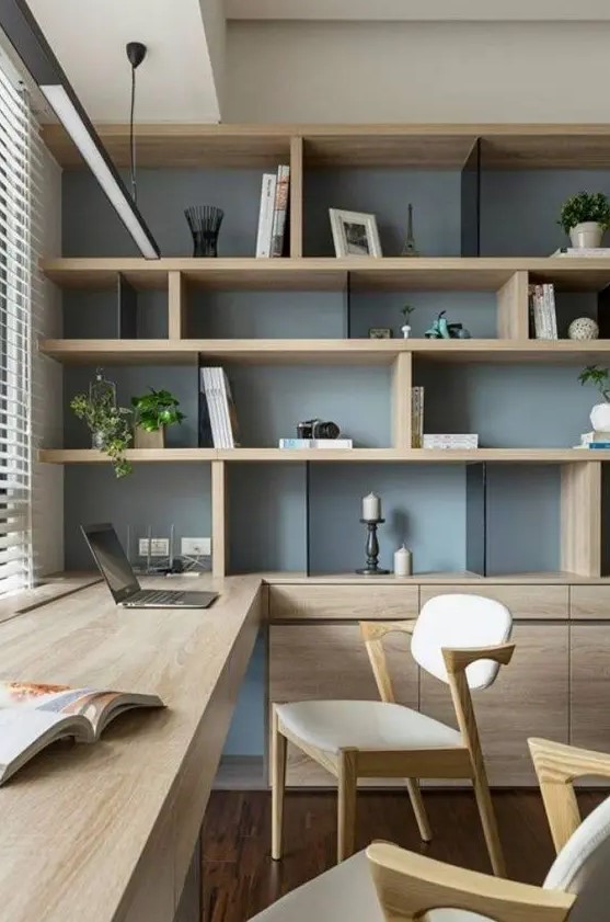 a chic contemporary home office with a storage unit that takes a whole wall, with open and closed storage compartments, a built-in desk and chic modern chairs