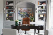 a refined grey home office with dove grey walls, a built-in storage unit, a dark-stained desk, white chairs and a hexagon chandelier
