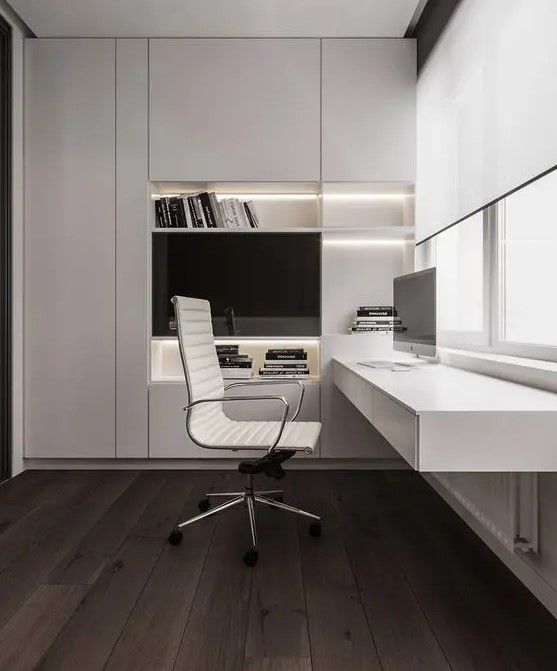 a refined minimalist home office with a large sleek built-in storage unit with built-in lights, a floating desk with storage, a chic white chair