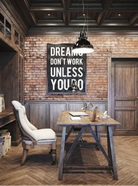 a vintage meets industrial home office with brick walls, paneling, a wooden desk and vintage chairs plus metal pendant lamps