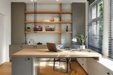 a welcoming contemporary home office with light grey storage units, stained shelves, a built-in matching desk and a black chair