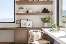 a welcoming neutral home office with amazing views and two desks, wooden shelves and a comfy chair, much natural light