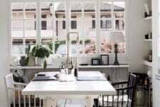 an airy Scandinavian home office with a white desk, a black and white chair, a pendant lamp, baskets and lamps is amazing