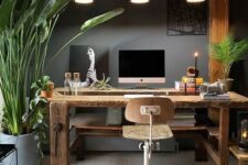 an eclectic home office with grey walls, a rustic wooden desk and beams, an industrial stool and pendant lamps