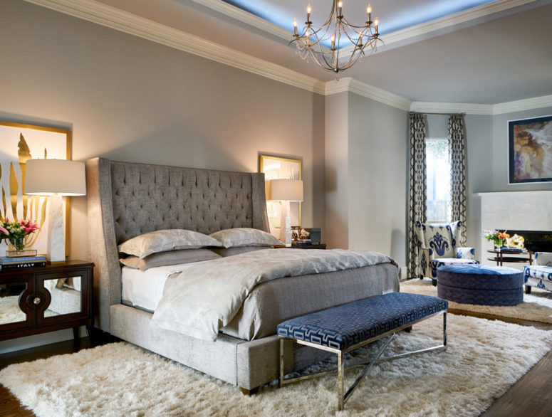 a light grey bedroom with much texture and a single navy accent - an upholstered bench