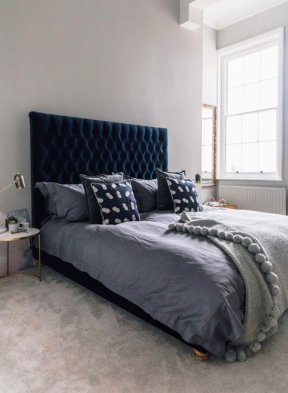 a beautiful bedroom done in dove grey with plenty of texture and a chic teal velvet upholstered bed