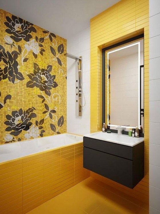 a beautiful modern bathroom clad with yellow skinny tiles, a floral tile accent wall, a floating black vanity and a lit up mirror is a lovely space