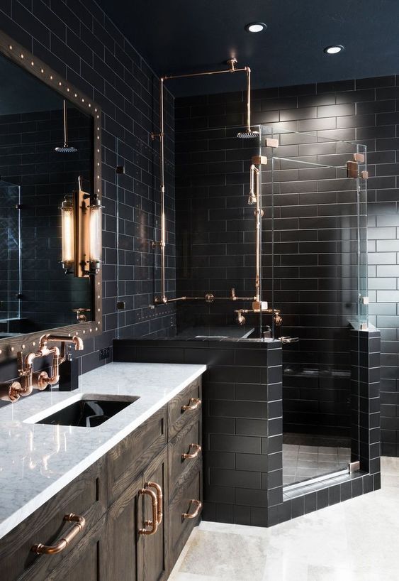 a black bathroom with subway tiles, a white floor, a dark-stained vanity with a white countertop and a mirror in a wooden frame