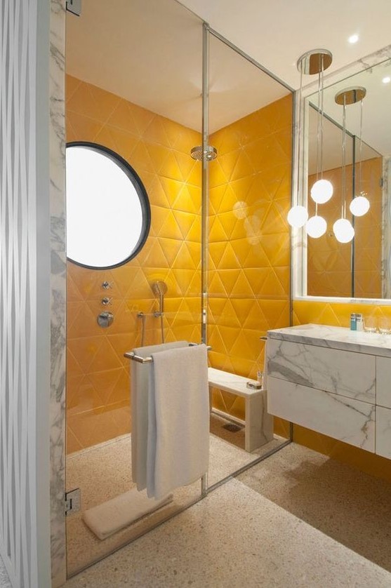 a bright contemporary bathroom with yellow triangle tile shower space, white marble and pendant lamps