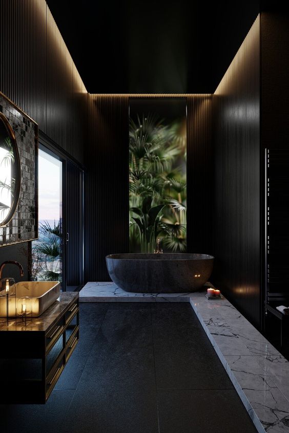 a catchy black bathroom with a white marble platform and a black tub on it, a floating vanity and a sink, a round mirror