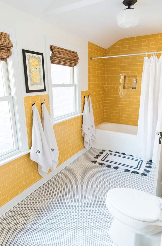 a cheerful bathroom with yellow tile walls, a penny tile floor and white appliances for a chic look